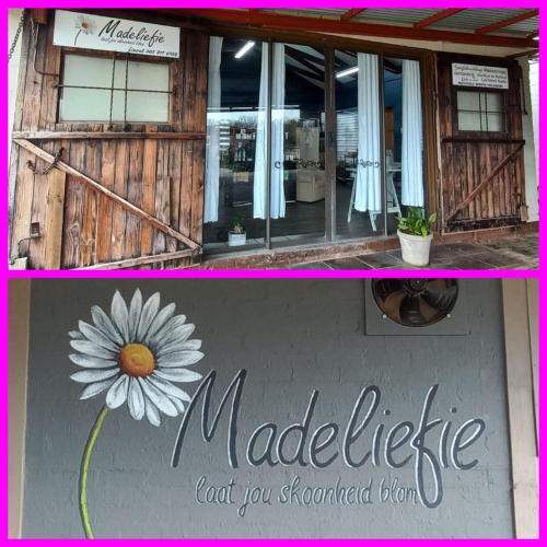 a picture of a building with a sign and a flower at Sonvanger Selfcatering in Orania