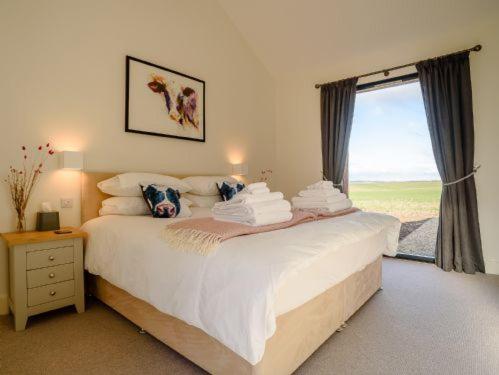 a bedroom with a large white bed with a window at Gallops in East Ilsley