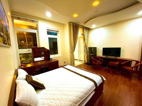 a bedroom with a bed and a desk and a television at Ngọc Hải Nam Hotel - Khách Sạn Nhơn Trạch in Nhơn Trạch