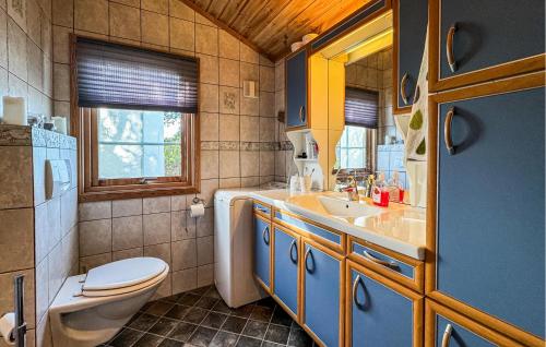 a bathroom with a toilet and a sink at Awesome Home In Fevg With Wi-fi in Fevåg