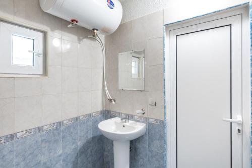 bagno con lavandino, servizi igienici e finestra di Вили Тихия Кът a Ribarica