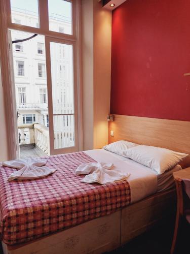 een slaapkamer met een bed met twee handdoeken erop bij Carlton Hotel in Londen