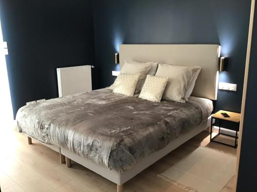 um quarto com uma cama grande e 2 almofadas em Au Coeur d'Omaha Beach - Colleville-sur-Mer - Gîte 1 em Colleville-sur-Mer