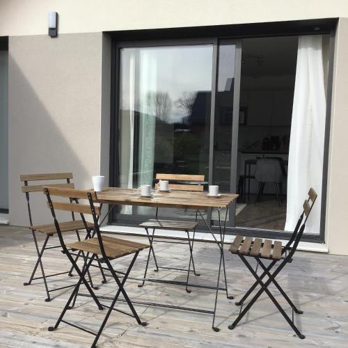 a wooden table with two chairs and a table and a table at Au Coeur d'Omaha Beach - Colleville-sur-Mer - Gîte 1 in Colleville-sur-Mer