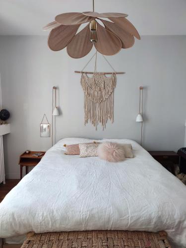 - une chambre avec un grand lit blanc et des oreillers dans l'établissement À 15 minutes de Paris, bel appartement au calme, à Colombes