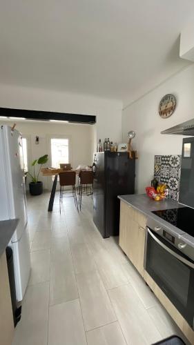 une cuisine avec une cuisinière et une table à l'intérieur dans l'établissement Le 8 - Maison - Jardin - BBQ - Aigues Mortes, à Aigues-Mortes
