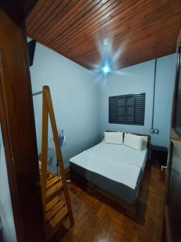 a bedroom with a bed and a wooden ceiling at HOSTEL BADULACK in Capitólio