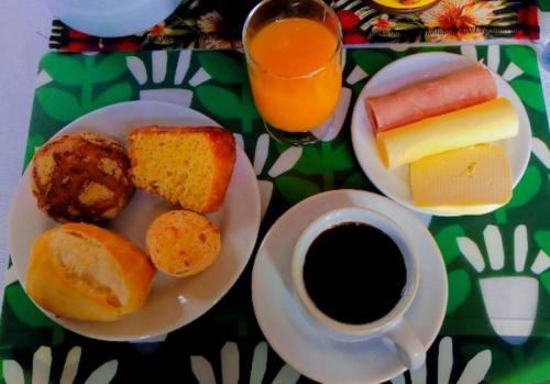 una mesa con un plato de comida y una taza de café en Quarto De Casal Econômico en Ouro Preto