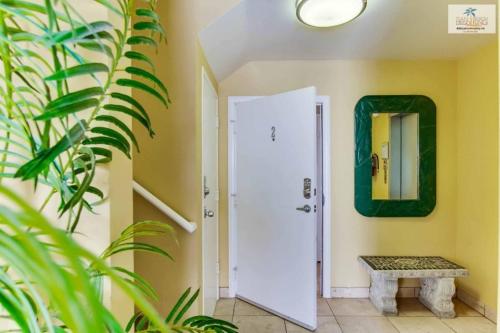 a hallway with a white door and a mirror at 101-luxury1 in San Diego
