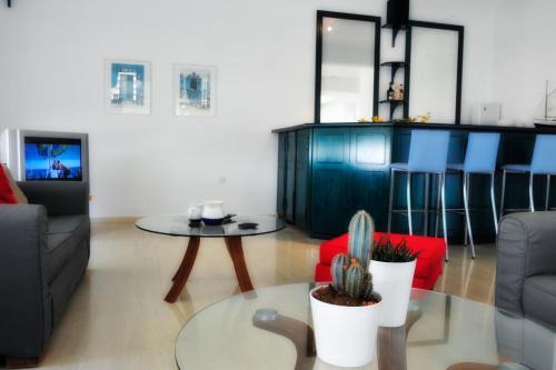 ein Wohnzimmer mit einem Sofa und einem Tisch mit einem Kaktus in der Unterkunft Ifigenia Hotel in Skiathos-Stadt