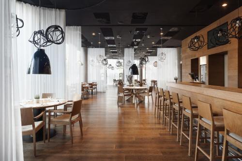 un restaurant avec des tables et des chaises ainsi qu'un bar dans l'établissement Fabrika Hotel, à Humpolec