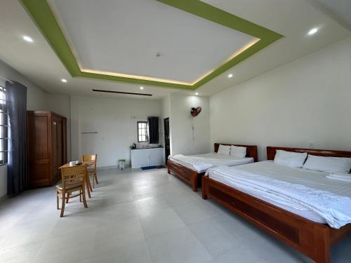 a bedroom with two beds and a table and chairs at OYO 1064 Phat Tai Hotel And Apartment in Da Nang