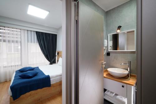 een kleine badkamer met een bed en een wastafel bij Meet İstanbul Hotel Kadikoy in Istanbul
