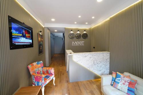 Meet İstanbul Hotel Kadikoy في إسطنبول: غرفة معيشة مع أريكة وتلفزيون على الحائط