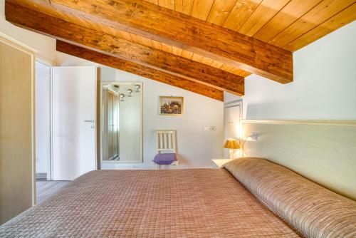 ein Schlafzimmer mit einem großen Bett und einer Holzdecke in der Unterkunft Casavacanzelemore - Casa Zara in Valfabbrica