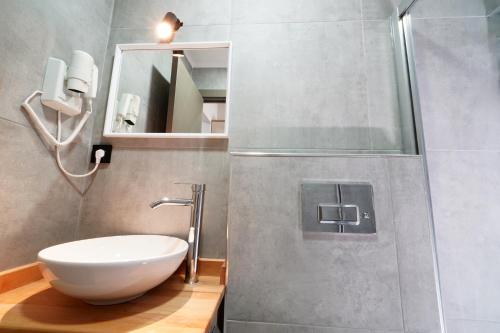 a bathroom with a white sink and a shower at Meet İstanbul Hotel Kadikoy in Istanbul