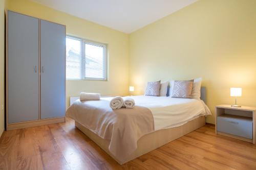 a bedroom with a large bed with two towels on it at Вили Тихия Кът in Ribarica