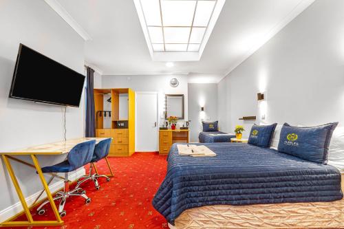 Jubilee Hotel Victoria في لندن: غرفة نوم بسرير وتلفزيون بشاشة مسطحة