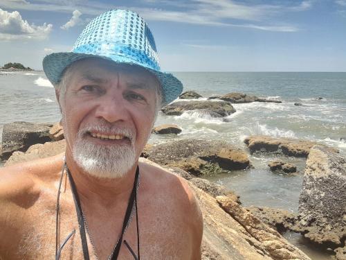 a man wearing a blue hat on the beach at Hostel Canto da Alegria in Itanhaém