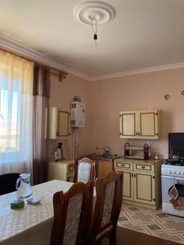 a kitchen with a table and chairs and a table and a kitchen with a stove at Тигран in Sevan