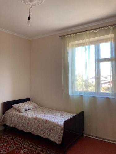 a bedroom with a bed and a window at Тигран in Sevan