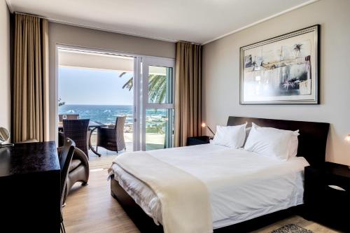 a hotel room with a bed and a view of the ocean at Houghton Steps in Cape Town
