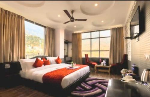 a bedroom with a large bed with a large window at Holiday Hill, Mcleodganj, Dharamsala in Dharamshala
