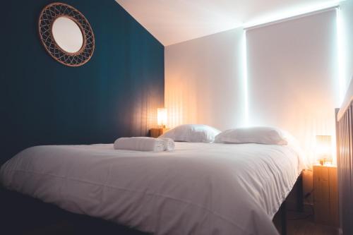 une chambre avec un grand lit blanc avec un miroir dans l'établissement Le Seigneur des anneaux, à Tours