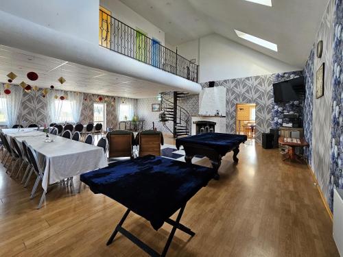 a dining room with a table and chairs and a fireplace at Šubrakkrasti in Vestiena