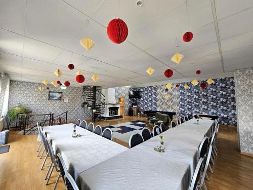 una habitación con filas de mesas y linternas rojas en Šubrakkrasti en Vestiena