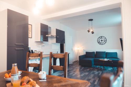 un salon avec une table et un canapé bleu dans l'établissement Le Cube Soma - Confortable T3, à Tours