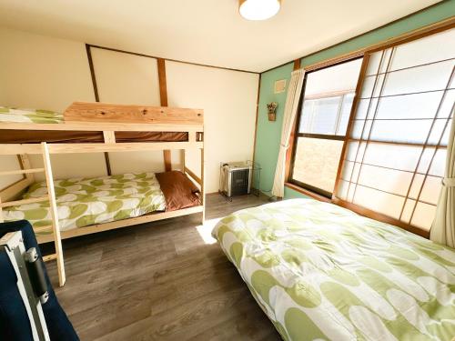 a bedroom with two bunk beds and a window at Mint / 11min walk to Noboribetsu st in Noboribetsu