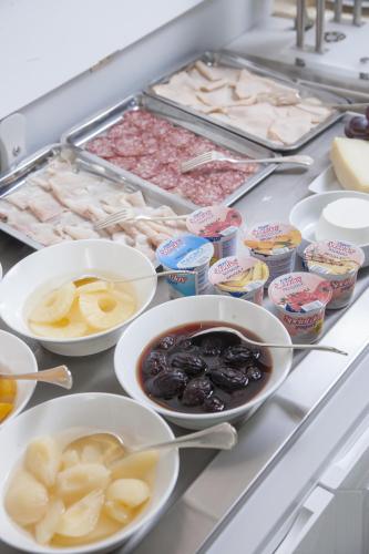 a counter with bowls of food and other foods at Hotel Grande Italia in Chioggia