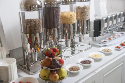 a buffet with bowls of fruit and other food at Hotel Grande Italia in Chioggia