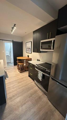 a kitchen with stainless steel appliances and a table at Modern One Bedroom Suite in Halifax