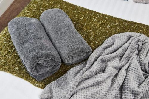 two towels are sitting on top of a blanket at The Moss x Monroe Suite - In Central Bath in Bath