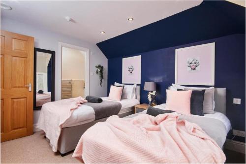 a bedroom with two beds and a blue wall at The Moss x Monroe Suite - In Central Bath in Bath