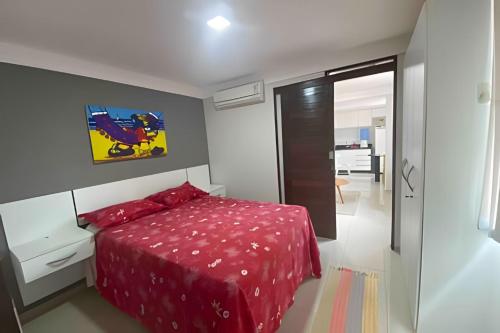 1 dormitorio con 1 cama con edredón rojo en 10ª Pirâmide Manaíra by Allmare Apartamentos en João Pessoa