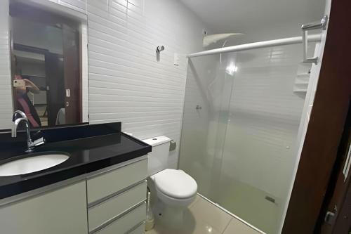 La salle de bains est pourvue de toilettes, d'un lavabo et d'un miroir. dans l'établissement 10ª Pirâmide Manaíra by Allmare Apartamentos, à João Pessoa