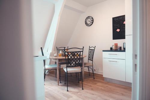 une table à manger avec des chaises et une horloge murale dans l'établissement Le Nœud du Diable - T3 spacieux, à Tours