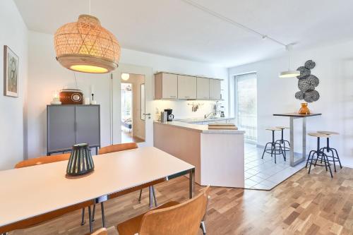 cocina y sala de estar con mesa y sillas en Sonnenflut, en Haffkrug