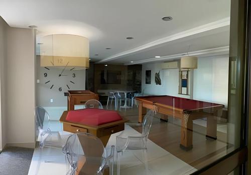 a dining room with a table and a clock on the wall at Luxor Paulo Miranda by Allmare Temporada in João Pessoa