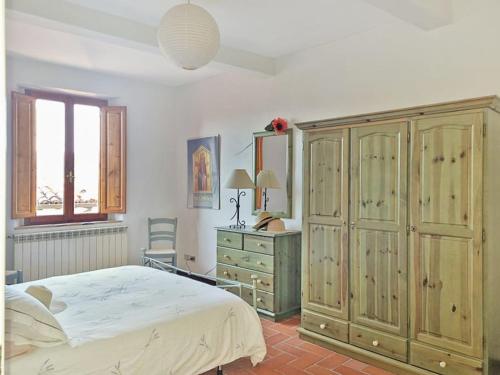 een slaapkamer met een bed, een dressoir en een raam bij * Apartment in Barga Old Town with amazing views in Barga