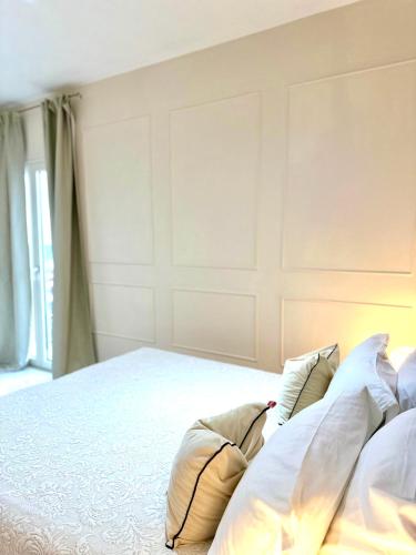 a bedroom with a large white bed with pillows at B&B Eyexei Domus in Agrigento