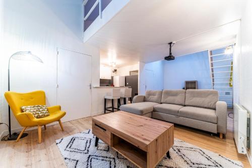 un salon avec un canapé et une table dans l'établissement Ravissante Maison Coeur de Lille, à Lille