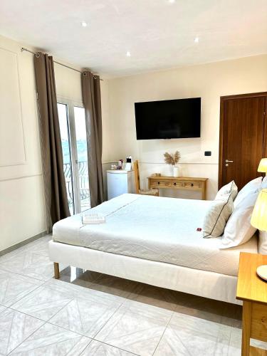 a bedroom with a large bed with a flat screen tv at B&B Eyexei Domus in Agrigento