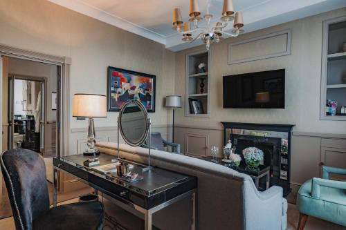 a living room with a desk and a mirror at Althoff St James's Hotel & Club London in London
