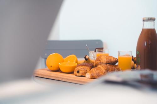- une planche à découper avec des oranges, des croissants et du jus d'orange dans l'établissement Charmante Mezzanine - Lamartine, à Tours