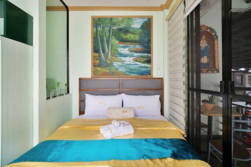 1 dormitorio con 1 cama con toallas en Golden V Primera Unit A, en Malolos