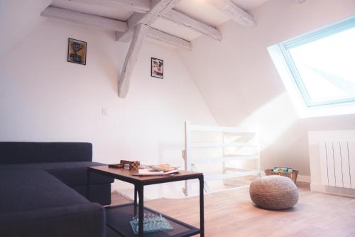 un salon avec un canapé et une table dans l'établissement Charmante Mezzanine - Lamartine, à Tours